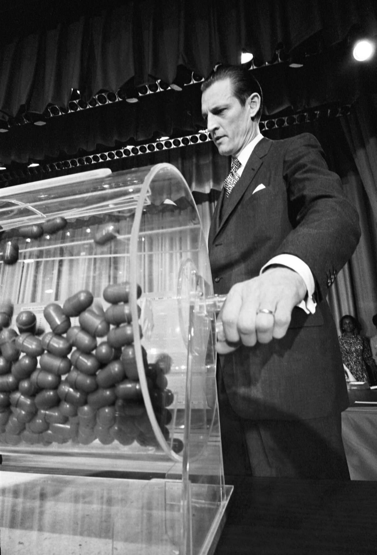 FT90MD Vietnam Draft. Curtis W. Tarr, director of the Selective Service System, making the draw at the annual draft lottery, Commerce Department Auditorium, Washington DC, February 1972.